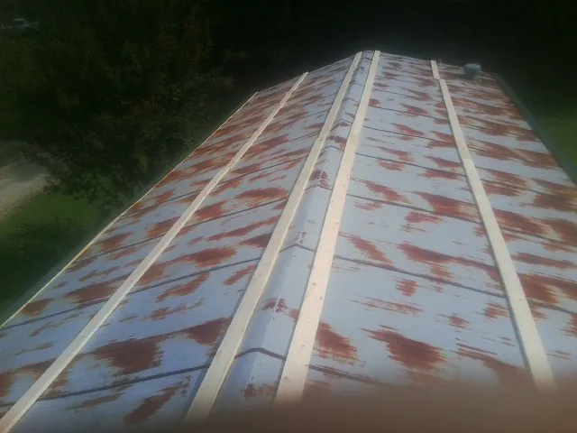 Rusted metal roof panels with new wood purlins before replacement — Storm Damage Roof Repair in Galena Park by Roofing Brothers