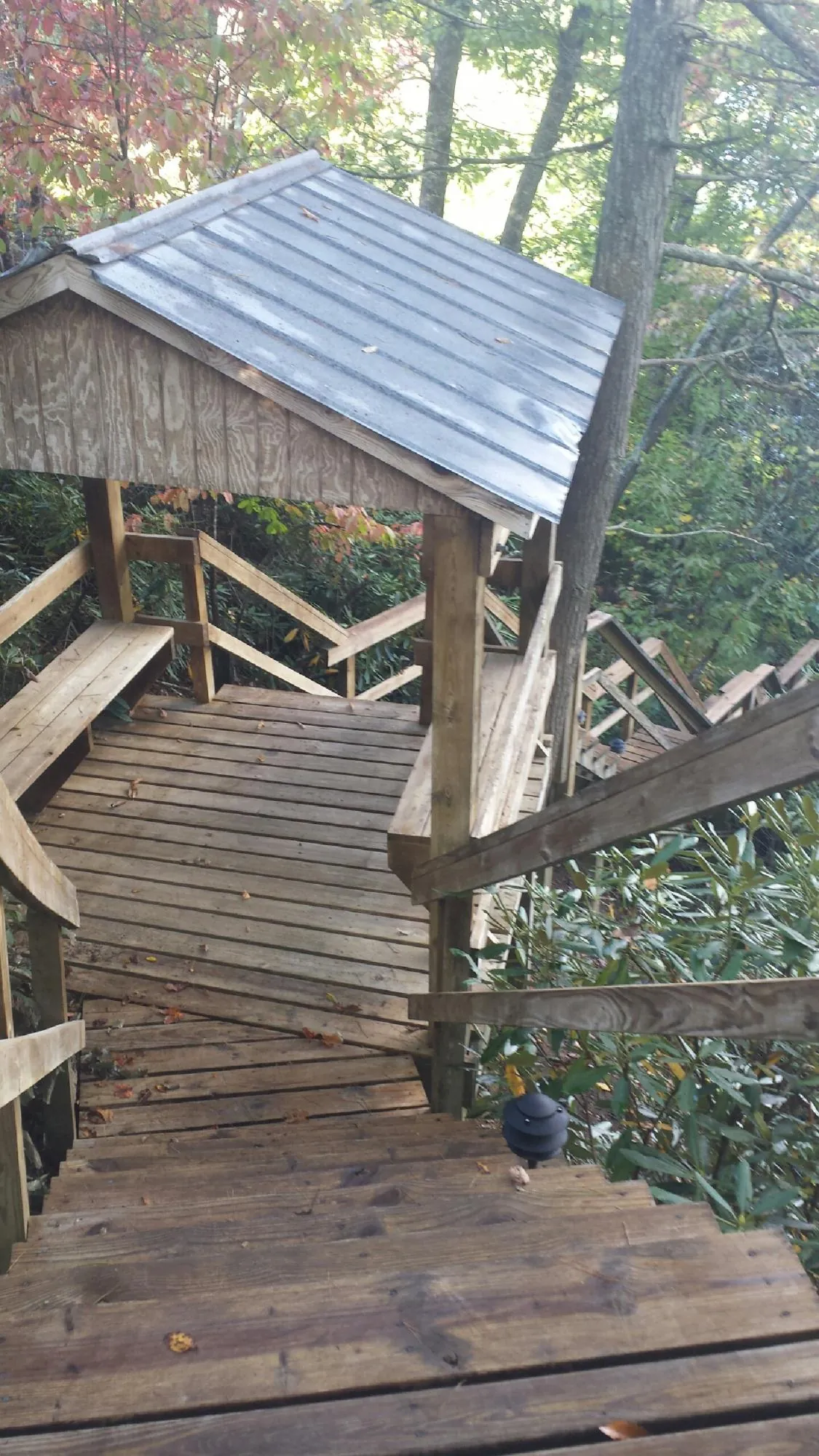 Metal roofed shelter over wooden steps on a wooded walkway — Skylight Repair & Installation work by our crew in Galena Park