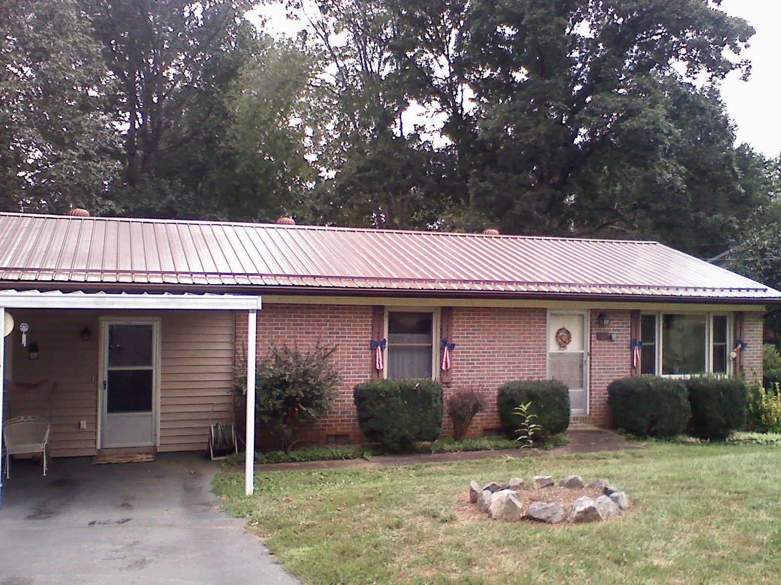 Bronze metal roof and carport on a brick ranch home — Roof Repair work by our crew in Galena Park