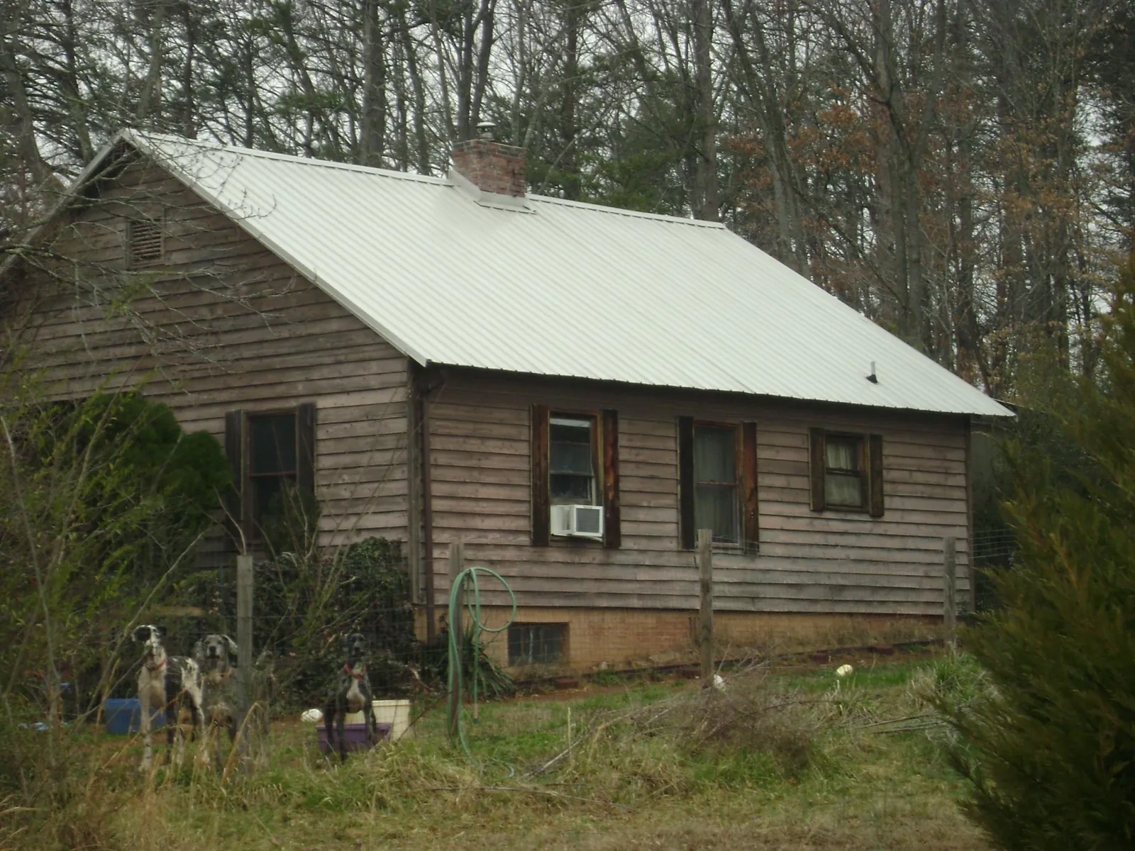 White metal roof on an old wood sided farmhouse, from a Metal Roof Installation job in Galena Park
